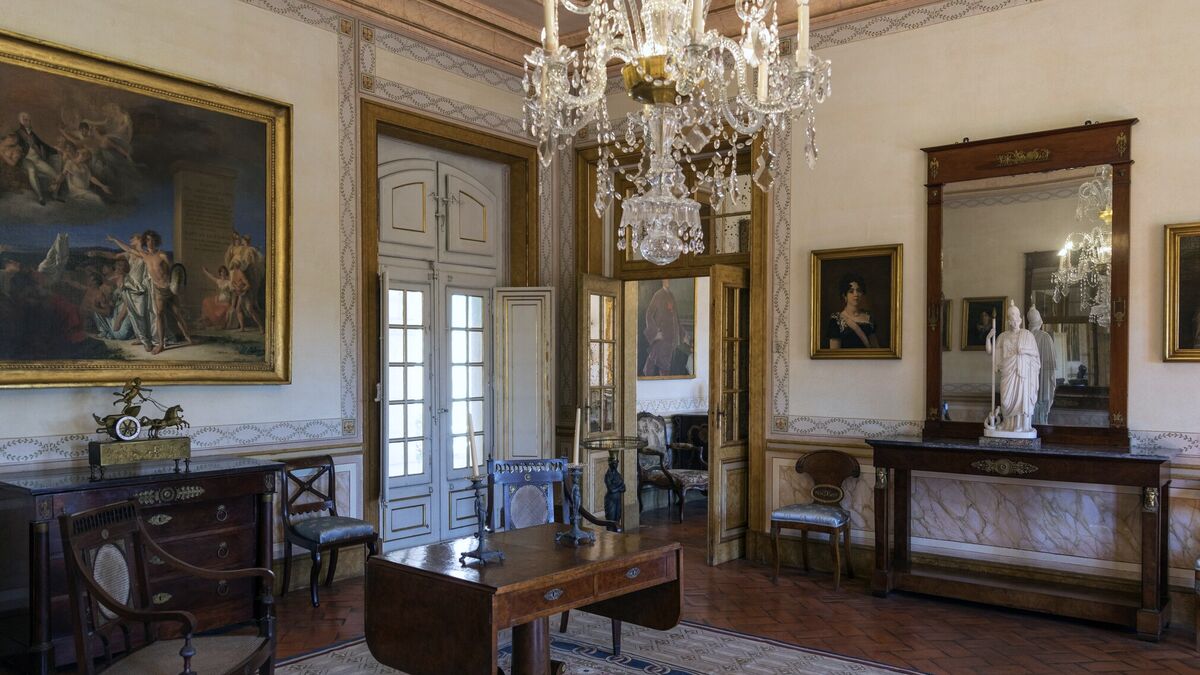 A palace salon hung with a crystal chandelier, an Empire pier mirror and gilt-framed paintings above mahogany furniture
