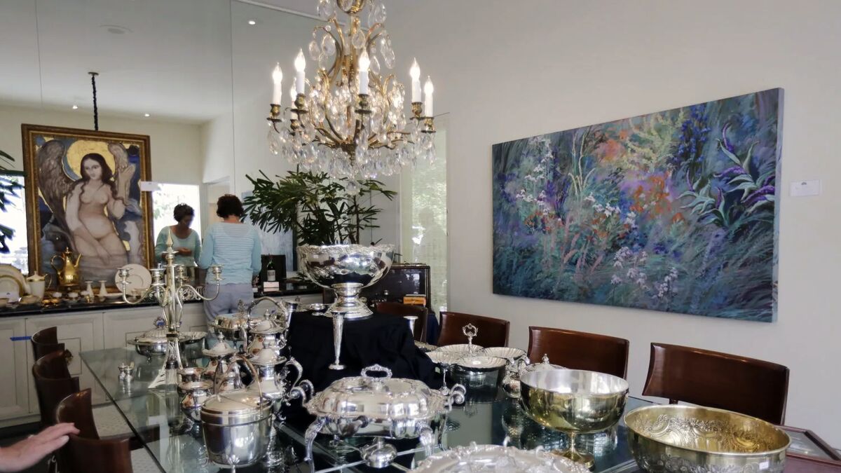 The Gary Germer gallery during a sale, with silver hollowware laid out beneath a chandelier