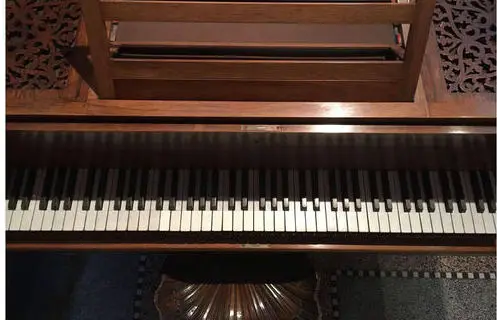 Looking down on the piano's keyboard and carved music desk